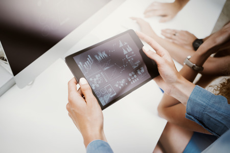 Woman Touching Screen Electronic Tablet Hand.Project Managers Researching Process.Business Team Working New Startup modern Office.HiTech Virtual Digital Charts Interfaces.Analyze market stock.Blurredの写真素材