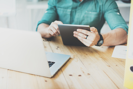 Social Trading Online markets.Man working wood table laptop Modern Interior Design Loft Place.Businessman Work Coworking Studio.Using Digital Tablet Market Reports.Blurred Background.Business Startupの写真素材