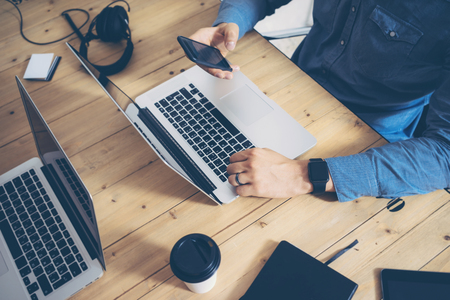 Businessmen Working Startup Wood Table Laptop Modern Office.Man Work Coworking Studio.Using Notebook,Typing Keyboard Smartphone Screen Report.Creative New Business Idea.Top view.Horizontalの写真素材