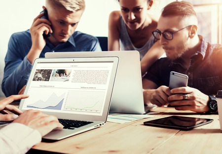 Young Business Team Brainstorming Process.Coworkers Startup Online Markets.Manager Using Modern Electronics Devices.Creative People Work New Project Wood Table.Notebook,Tablet,Smartphone.Blurredの写真素材