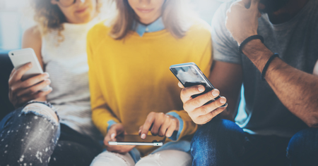 Closeup Group Adult Hipsters Friends Sitting Sofa Using Hands Modern Smartphone Tablet.Business...