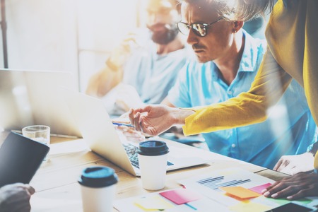 Young Group Coworkers Making Great Business Decisions.Creative Team Discussion Corporate Work Concept Studio.New Startup Idea Presentation Laptop.People Working Wood Table Documents.Blurred