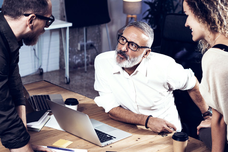 Young team of coworkers making great work discussion in modern office.Bearded man talking with...