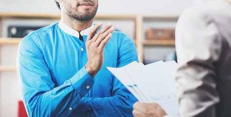 Closeup photo of two coworkers making a great business discussion in modern office.Successful confident hispanic businessman talking with young woman. Horizontal wide, blurred backgroundの写真素材