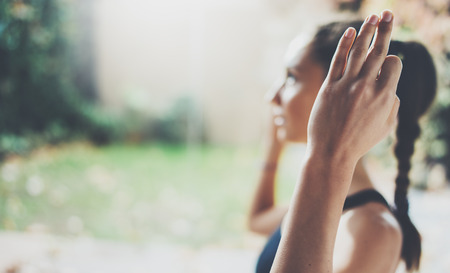 Closeup view of female hands.Gorgeous young woman practicing yoga indoor.Beautiful girl smiling during practice class.Calmness and relax,female happiness concept.Horizontal,blurred backgroundの写真素材