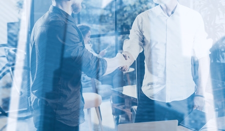 Double exposure concept.Business partnership handshake.Photo two bearded businessmans handshaking process.Successful deal after great meeting in modern office.Horizontal, blurred backgroundの写真素材