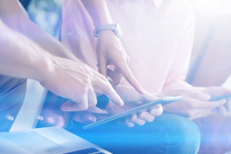 Closeup view of two hands pointing on digital tablet.Young business team working with new startup project.Blurred background, visual effect. Horizontalの写真素材