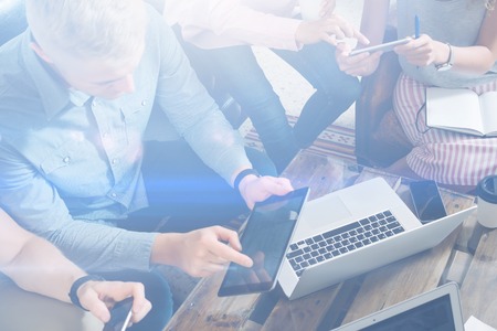 Group of young coworkers making great business decisions.Creative team discussing new work concept at modern office.Man using digital tablet, laptop on the table. Visual effects.の写真素材