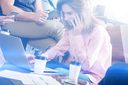 Account manager working process.Young business woman work with new startup project in office.Analyze document, plans.Modern laptop on wood table, papers, documents.Horizontal, blurred, flare.の写真素材