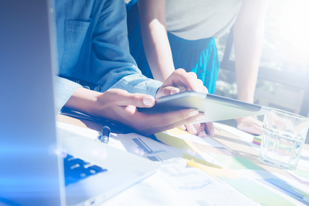 Closeup view of female hands holding modern digital tablet.Girl pointing the screen with your finger.Concept business people working with mobile devices.Visual effect,flares,blurred background.の写真素材