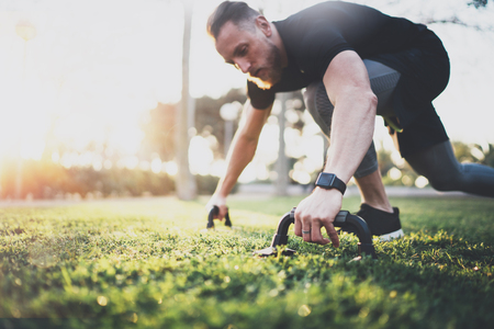 Healthy lifestyle concept.Young athlete exercising push up outside in sunny park. Fit shirtless male fitness model in crossfit exercise outdoors.Sport fitness man doing push-ups.の写真素材