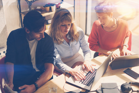 Coworking process at sunny office.Business team sitting at meeting room and using mobile devices.Horizontal.Blurred background.の写真素材