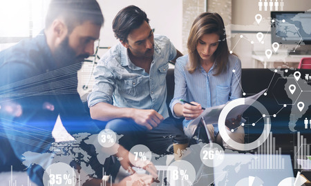 Coworking process in a sunny office.Young Business team making great sratup idea at meeting room.Concept of digital diagram,graph interfaces,virtual screen,connections icon on blurred background.の写真素材