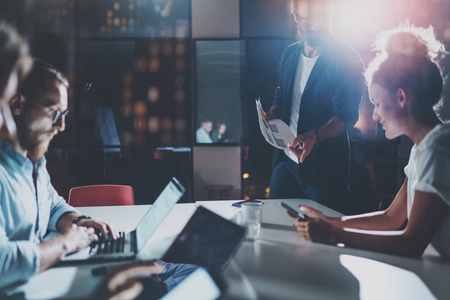 Business people brainstorming concept.Coworkers working at night office.Horizontal, flares effect.Blurred background.Cropped.の写真素材