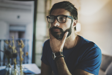 Closeup portrait of Handsome bearded man spending rest time at the modern home at evening.Horizontal. Blurred background.の写真素材