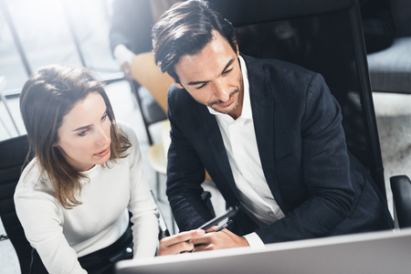 Teamwork process at lightful office.Young business people working with new finance startup project.Blurred background.Horizontal.の写真素材
