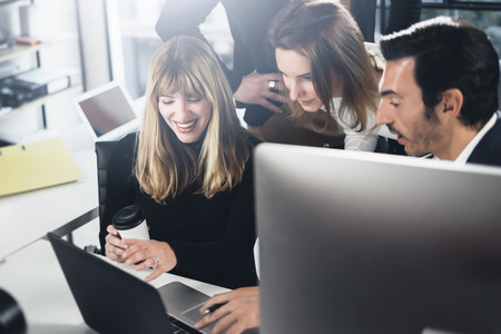 Business people using computers and laptops. Coworkers working together in modern office.Horizontal.Blurred background.の写真素材