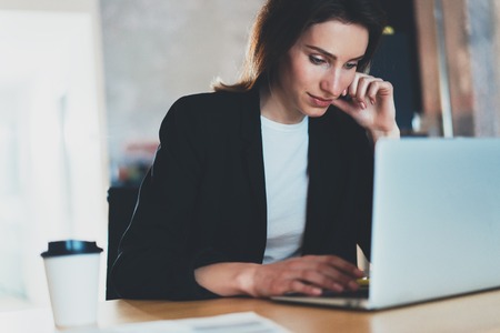 Portrait of Young beautiful businesswoman using laptop computer at modern office.Blurred background.Horizontal.の写真素材