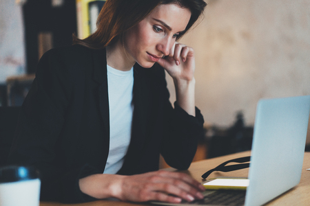 Closeup portrait of Young beautiful businesswoman using laptop computer at modern office.Blurred background.Horizontal.の写真素材