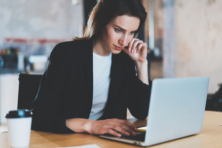 Young woman working at modern office loft.Blurred background.Horizontal.の写真素材