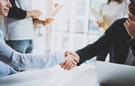 Concept two coworkers handshaking process.Business partnership handshake.Successful deal after great meeting at sunny meeting room.Cropped.の写真素材