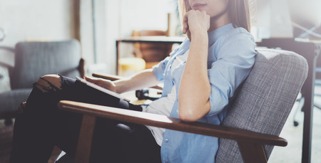 Handsome young blonde wearing glasses and using electronic touch tablet computer on sunny workplace.Horizontal. Blurred background.の写真素材
