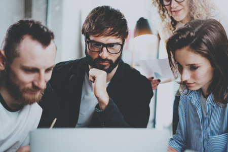 Group of young entrepreneurs are looking for a business solution during working time at sunny...