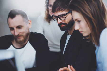 Group of young entrepreneurs are looking for a business solution during working time at sunny...