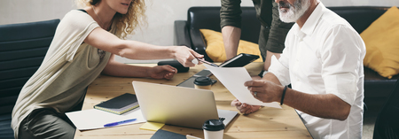 Young team of coworkers making great work discussion in modern office.Bearded man talking with marketing director and assistant manager.Wide.の写真素材