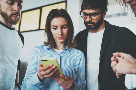 Coworkers business meeting concept.Young women holding mobile smartphone hand and showing information to her colleaguesの写真素材