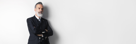 Portrait of bearded attractive gentleman wearing trendy suit over empty white background. Copy Paste text space. Wide.の写真素材