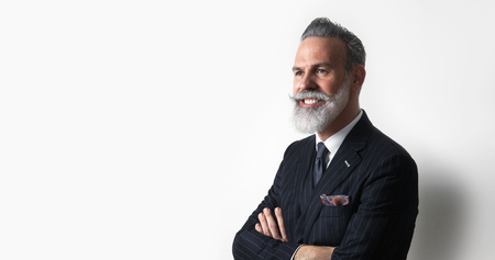 Portrait of bearded attractive gentleman wearing trendy suit over empty white background. Copy Paste text space. Wide.の写真素材