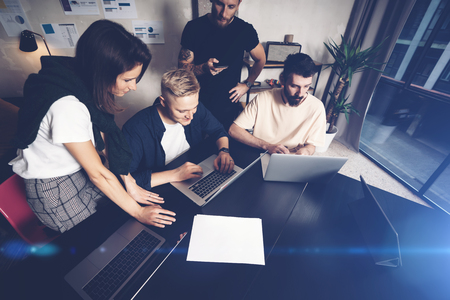 Coworkers team at work. Group of young business people in trendy casual wear working together in creative officeの写真素材