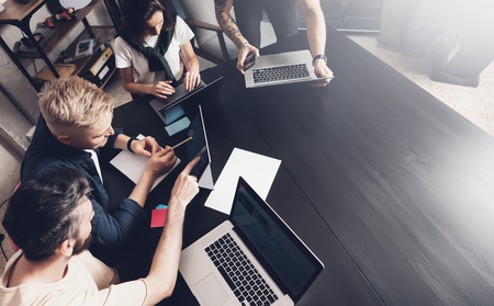 Business professionals at working moments. Group of young confident coworking people analyzing data using computer while spending time in the office.の写真素材