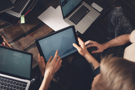 Successful business team at work. Group of young business people working with laptop and...