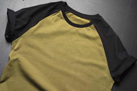 Blank vintage fold t-shirts on dark wooden surface background. Front view of American Hipsters vintage classic clothesの写真素材