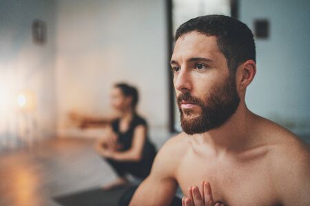 Yoga Practice Exercise Class Concept. Young woman and man practicing yoga indoors. Two sporty people doing exercises.の写真素材