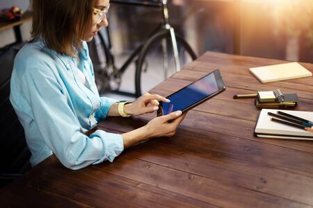 Woman pointing on digital tablet screen, chatting in social networks, meeting website, searching internet, sending sms, using text messenger or online banking. Close up of female hands holding deviceの写真素材