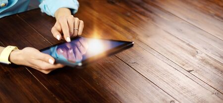 Woman pointing on digital tablet screen, chatting in social networks, meeting website, searching internet, sending sms, using text messenger or online banking. Close up of female hands holding deviceの写真素材