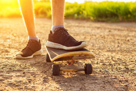skateboarding on the road at sunset , summer entertainment.