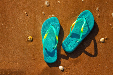 blue sandals on the beach , the concept of rest on the sea.の写真素材