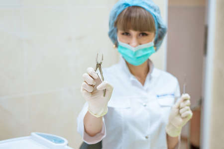 woman doctor in mask with tools in hand.の写真素材