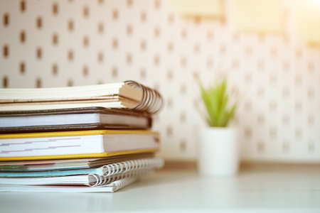 Desktop stack of notebooks and  flower in the background, soft focus.の写真素材