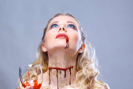 bright make-up on the face of a beautiful woman holding a glass of wine in her hand.の写真素材