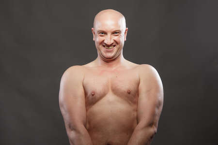 A man with a naked torso shows muscles in the background.の写真素材