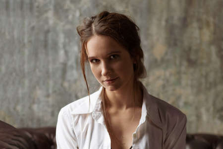 Portrait of a sexy young woman in a white shirt.