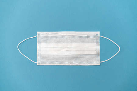 Surgical white mask for protection on a blue background.