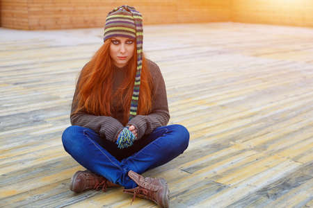 Portrait of a woman with a bright make up in a funny hat looking at the camera.