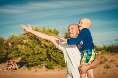 happy father and son walking on the beach.の写真素材
