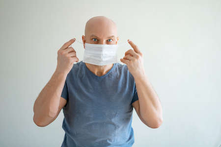 A man puts a medical mask on his face.の写真素材